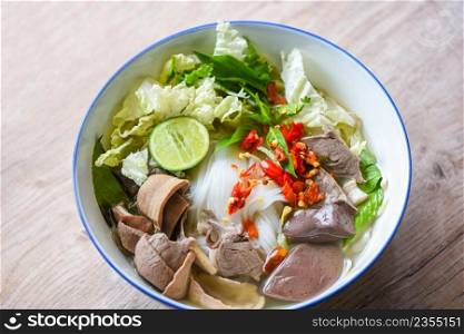 Noodle soup bowl pork blood pudding and pork offal, Thai rice vermicelli noodle with clear soup and fresh vegetable set with lemon sprouts bean pepper chili sauce Thai traditional menu food