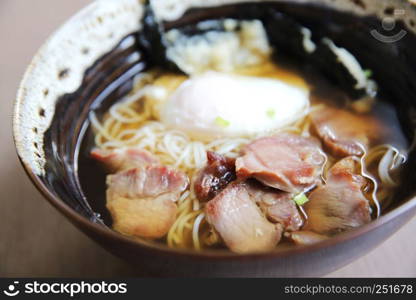 Noodle with pork and egg on wood background