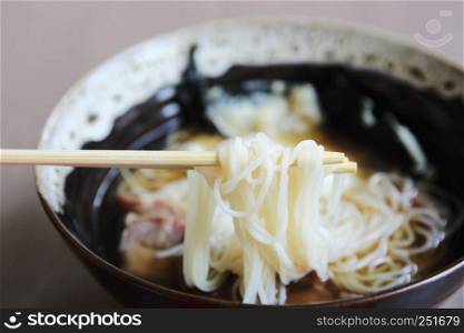 Noodle with pork and egg on wood background