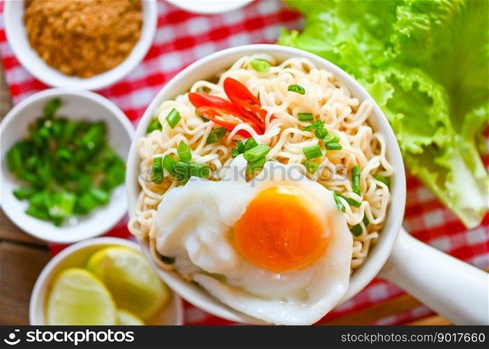 noodles bowl with boiled egg vegetable spring onion lemon lime lettuce celery and chili on table food , instant noodles cooking tasty eating with bowl noodle soup - top view 