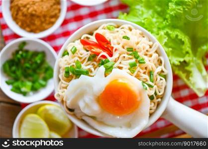noodles bowl with boiled egg vegetable spring onion lemon lime lettuce celery and chili on table food , instant noodles cooking tasty eating with bowl noodle soup - top view 