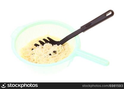 noodles in green colander isolated on a white background