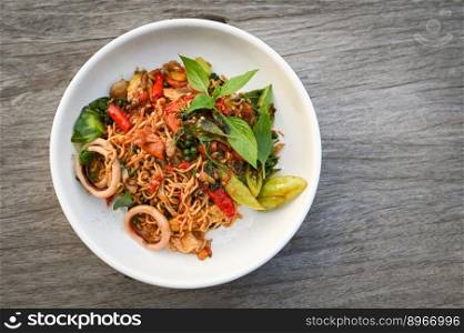 noodles plate with instant noodles stir fried with vegetables herb spicy tasty appetizing asian noodles mix seafood stir fried squid with basil and chilli pepper - top view 
