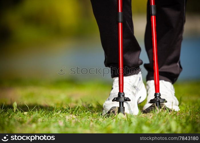 Nordic walking. Closeup of female legs hiking in the park. Active and healthy lifestyle.