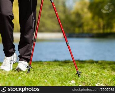 Nordic walking. Closeup of female legs hiking in the park. Active and healthy lifestyle.