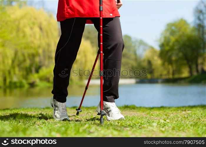 Nordic walking. Closeup of female legs hiking in the park. Active and healthy lifestyle.