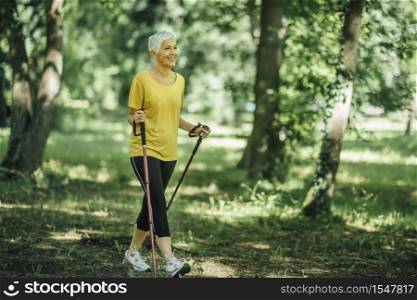 Nordic walking exercise. Active mature woman enjoying the nature. Nordic Walking Exercise