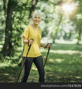 Nordic walking exercise. Active mature woman enjoying the nature. Nordic Walking Exercise