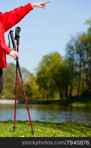 Nordic walking. Sticks in the park. Hand showing pointing at blank on the sky. Active healthy lifestyle.