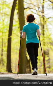 Nordic walking. Woman hiking in the forest or park. Active and healthy lifestyle.