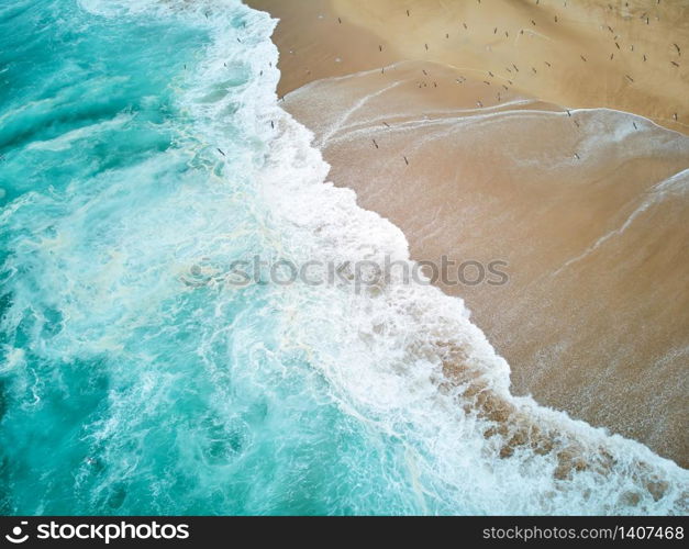 North Beach in Nazare Portugal with foaming waves and flying seagulls