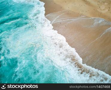 North Beach in Nazare Portugal with foaming waves and flying seagulls