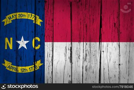 North Carolina grunge wood background with North Carolinian State flag painted on aged wooden wall.