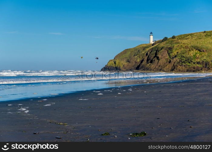 North Head Lighthouse at Pacific coast, Cape Disappointment, built in 1898, WA, USA. Coast guard helicopters in the sky.