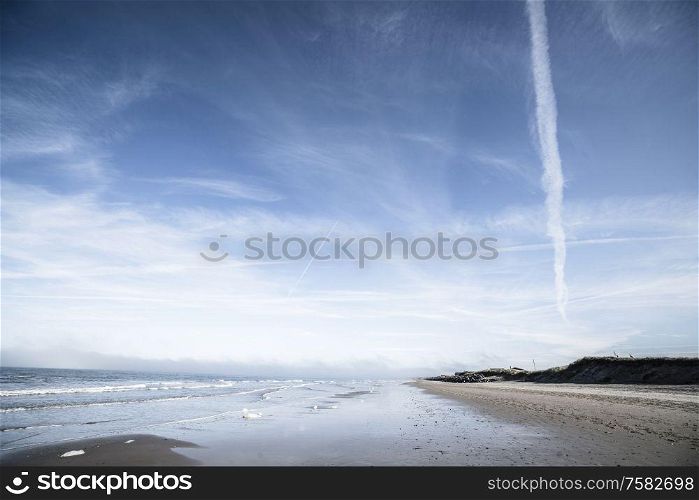 Northern beach with waves coing in under a dramatic blue sky
