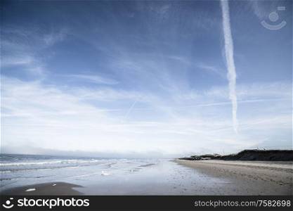 Northern beach with waves coing in under a dramatic blue sky