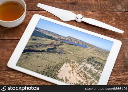 northern Colorado foothills - Park Creek and Reservoir in summer scenery, reviewing aerial image on a digital tablet