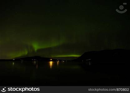 Northern light reflected on the Hafravatn lake, Iceland. Northern light in Hafravatn lake, Iceland