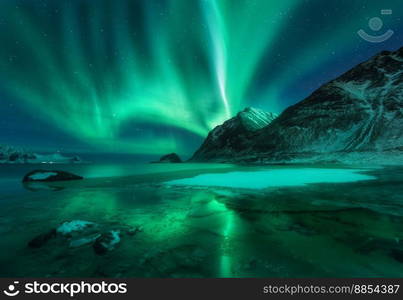 Northern lights above Vik beach at night in Lofoten islands, Norway. Beautiful aurora borealis in winter. Starry sky with polar lights. Landscape with aurora, sea coast, stones, snowy mountains. Space