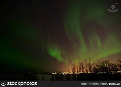 Northern lights and Reykjavik lights from Heidmork, Iceland. Northern lights from Heidmork, Iceland