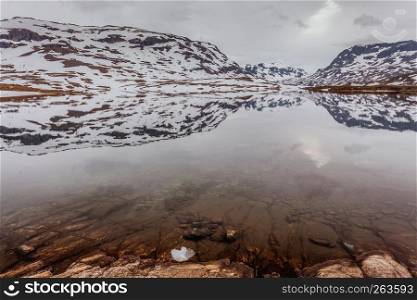 Norway hiking area, scenic mountains landscape, hills and frozen lake. Norway scenic mountains with frozen lake.