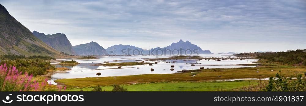 Norway landscape cloudy summer panorama, fjord and mountains in the background. Overcast sky