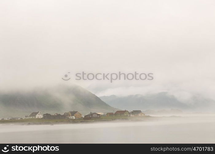 Norway village in clouds of fog on lofoten islands. Cloudy Nordic day.