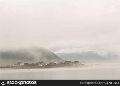 Norway village in clouds of fog on lofoten islands. Cloudy Nordic day.