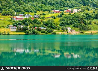 Norwegian country house in the mountains on sea shore. Beautiful coastline fjords landscape and village, Scandinavia Europe. Norwegian country houses in the mountains on lake shore
