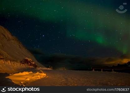 Norwegian Lofoten. Winter night. Many stars in the sky. Thick clouds on the horizon. Aurora Borealis. Northern Lights over Thick Clouds