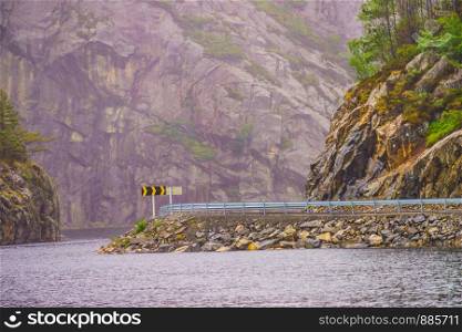 Norwegian mountains landscape. Empty road along fjord.. Road and fjord landscape in Norway