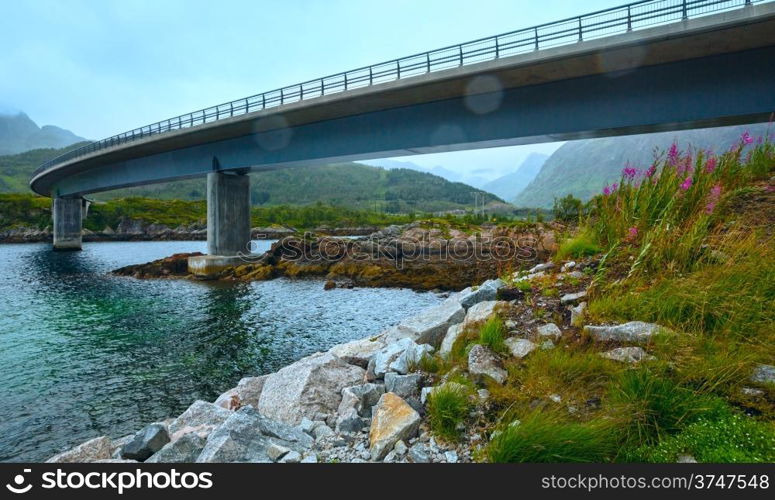 Norwegian Sea cloudy night view with stony coast and bridge (not far Vagan, Norway).