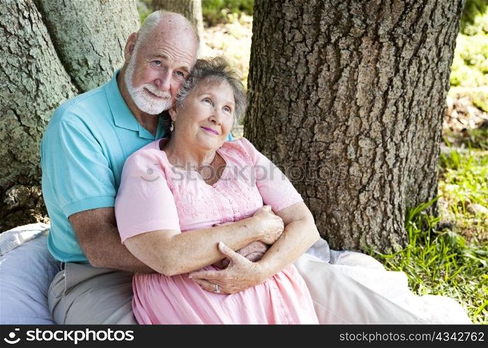 Nostalgic senior couple sitting outdoors and remembering.