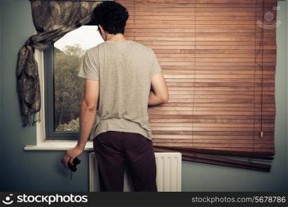 Nosy neighbor with binoculars standing by his window