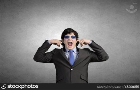 Not a sound. Annoyed businessman covering his ears with his hands