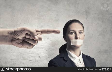 Not a word she will say. Young speechless businesswoman with adhesive tape on mouth