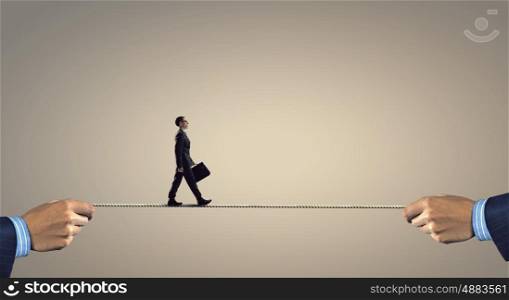 Not afraid to risk. Businessman walking on rope presenting risk and danger concept