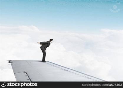 Not afraid to risk. Super man jumping from edge of airplane wing