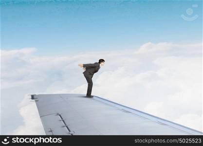 Not afraid to risk. Super man jumping from edge of airplane wing
