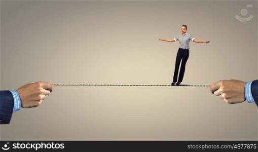 Not afraid to risk. Young businesswoman walking on rope presenting risk and challenge concept