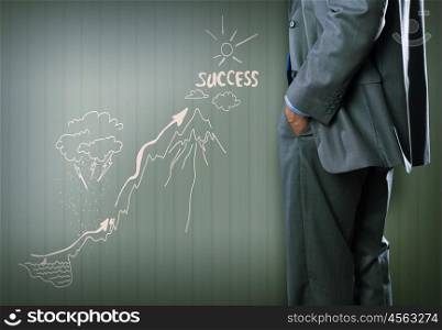 Not an easy way to the top. Bottom view of businessman and sketches of ideas on wall