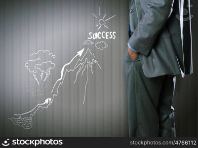 Not an easy way to the top. Bottom view of businessman and sketches of ideas on wall