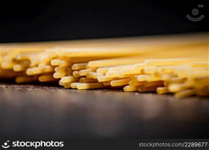 Not boiled spaghetti dry on a black background. High quality photo. Not boiled spaghetti dry on a black background.