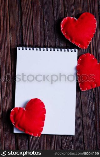 note book and hearts on the wooden table