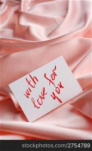 "Note on beige silk. With an inscription " With love for you ". Drawn by lipstick"