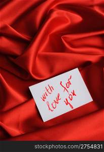 "Note on red silk. With an inscription " With love for you ". Drawn by lipstick"