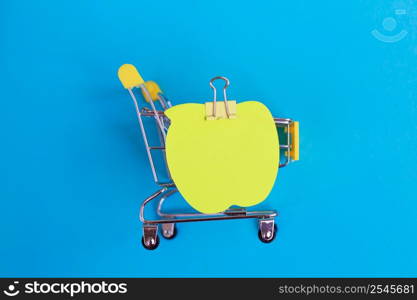 Note paper on shopping cart isolated on a blue background. Note paper on shopping cart isolated on blue background