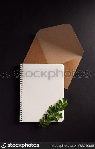 Notebook and branch with leaf at paper black background texture. Creative idea