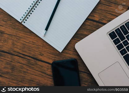 Notebook and computer on brown wood floor