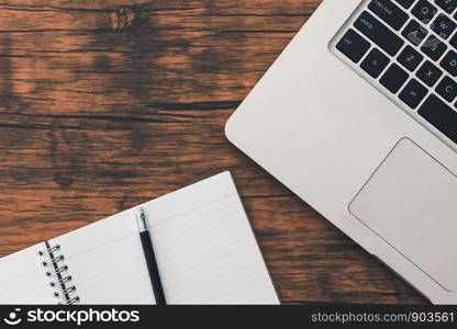 Notebook and computer on brown wood floor